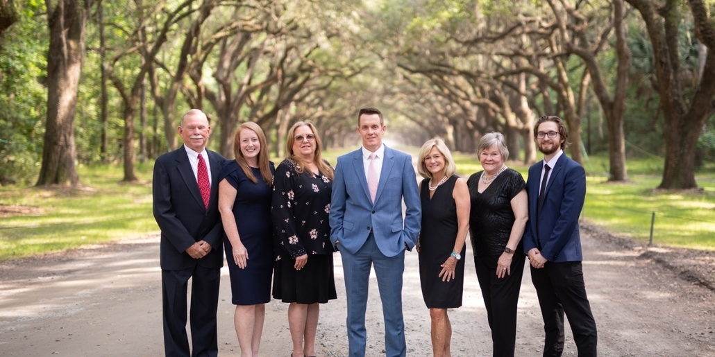 A Picture of the Clements McGovern Financial Consulting Group standing on a dirt road surrounded by overhanging trees